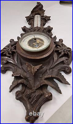 A richly carved large barometer with a thermometer IN BLACK FOREST STYLE